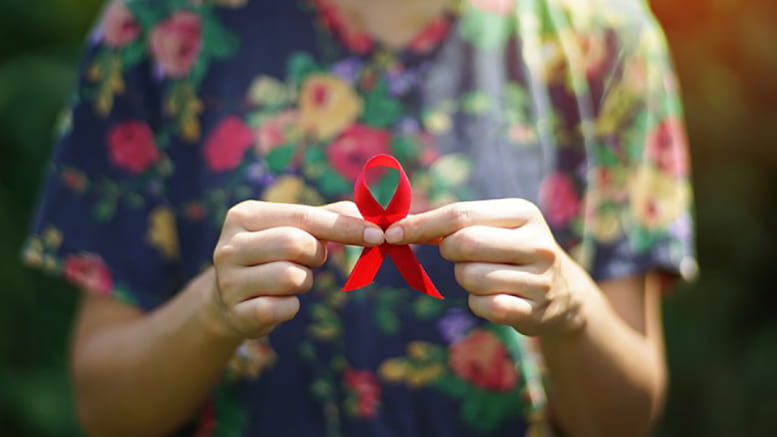 Image of someone holding a red ribbon