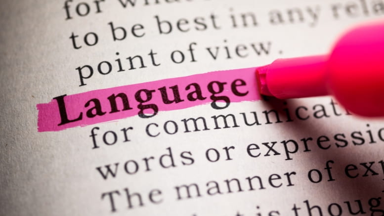 The word "language" being highlighted with a pink marker in a sentence on a page